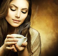Eine echte Kaffeegenießerin Eine junge Frau betrachtet leidenschaftlich Ihre Kaffeetasse, kurz davor ihn zu genießen